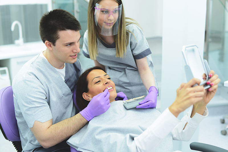 woman looking at her smile at the dentist