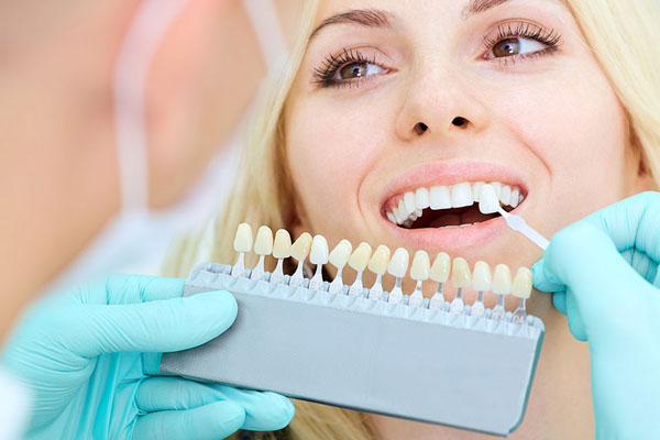 woman picking out her veneer shade at the dentist