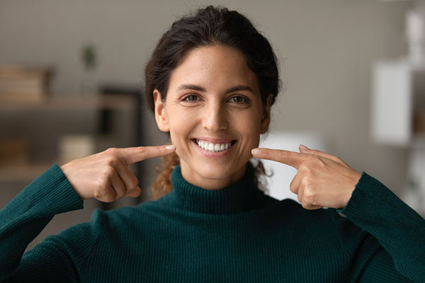 woman pointing at her smile