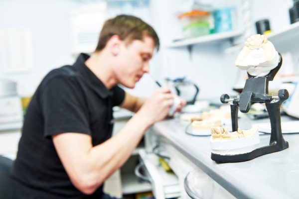 dental technician working on dental restoration in lab